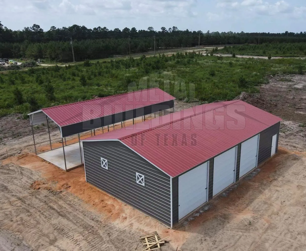 Aerial view of metal buildings with red roofs and overhead doors