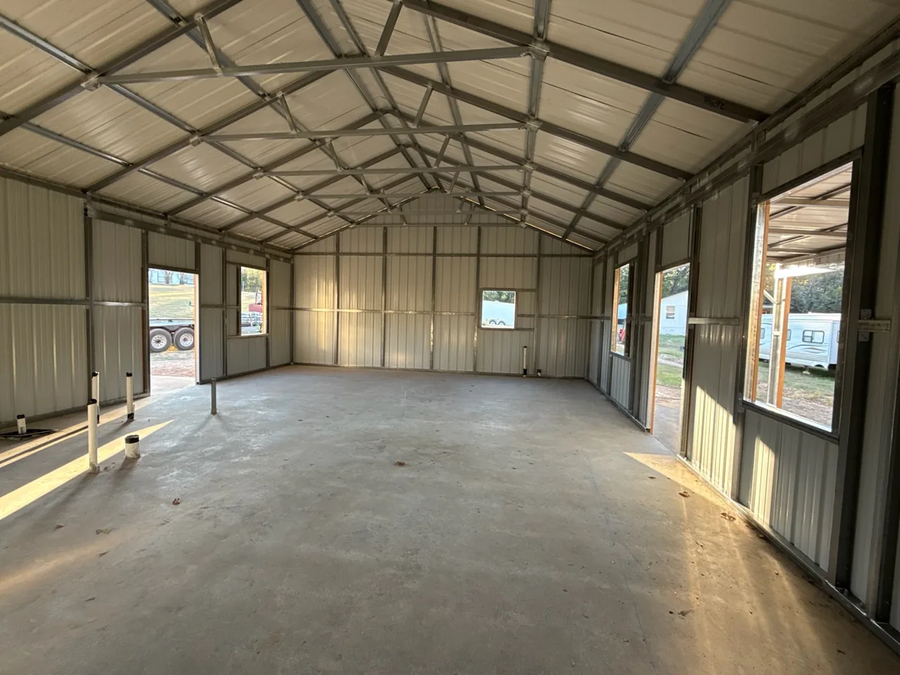Open metal building interior with windows along the sidewalls